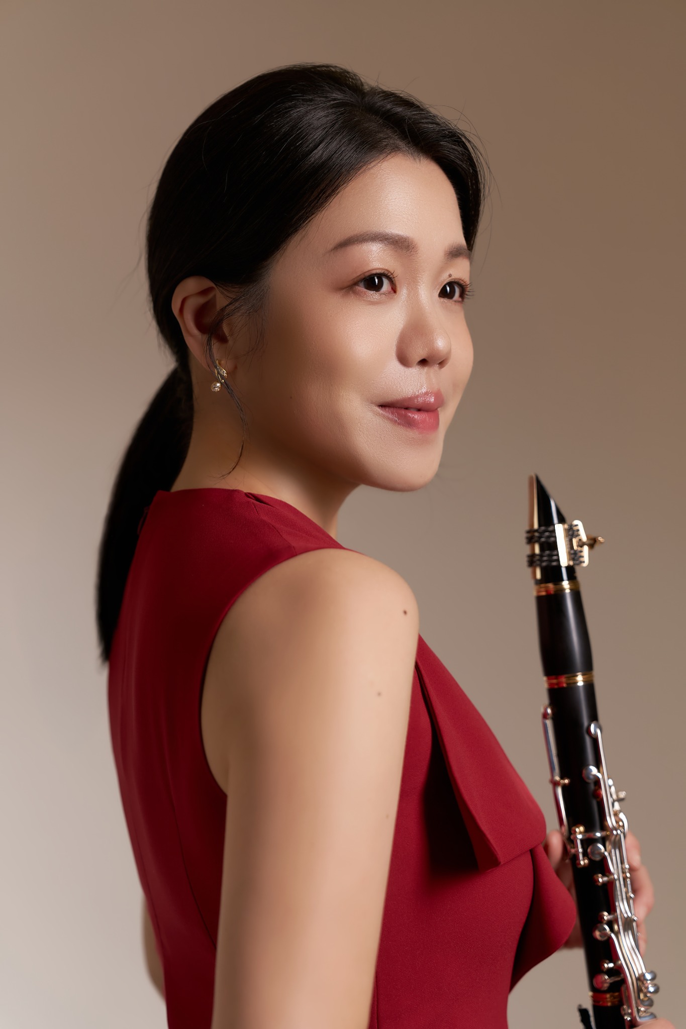 Pei-Lun Tsai in a red dress holding her clarinet